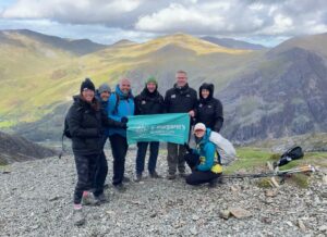 The Air-Seal team are holding a St Margaret's banner halfway up Mt. Snowdon